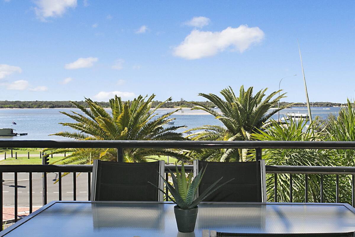 Ein Balkon mit Meerblick, einer Kübelpflanze und zwei Stühlen.
