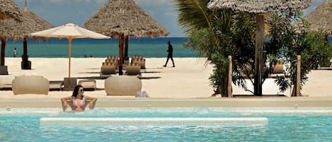 Een buitenzwembad, parasols voor strand/zwembad