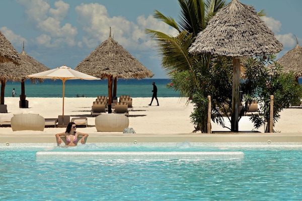 Alberca al aire libre, sombrillas en la alberca y camastros