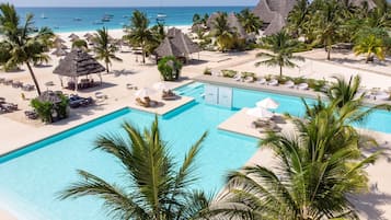 Alberca al aire libre, sombrillas en la alberca y camastros