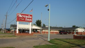 A Nevada Inn sign with a welcoming message and a flag.
