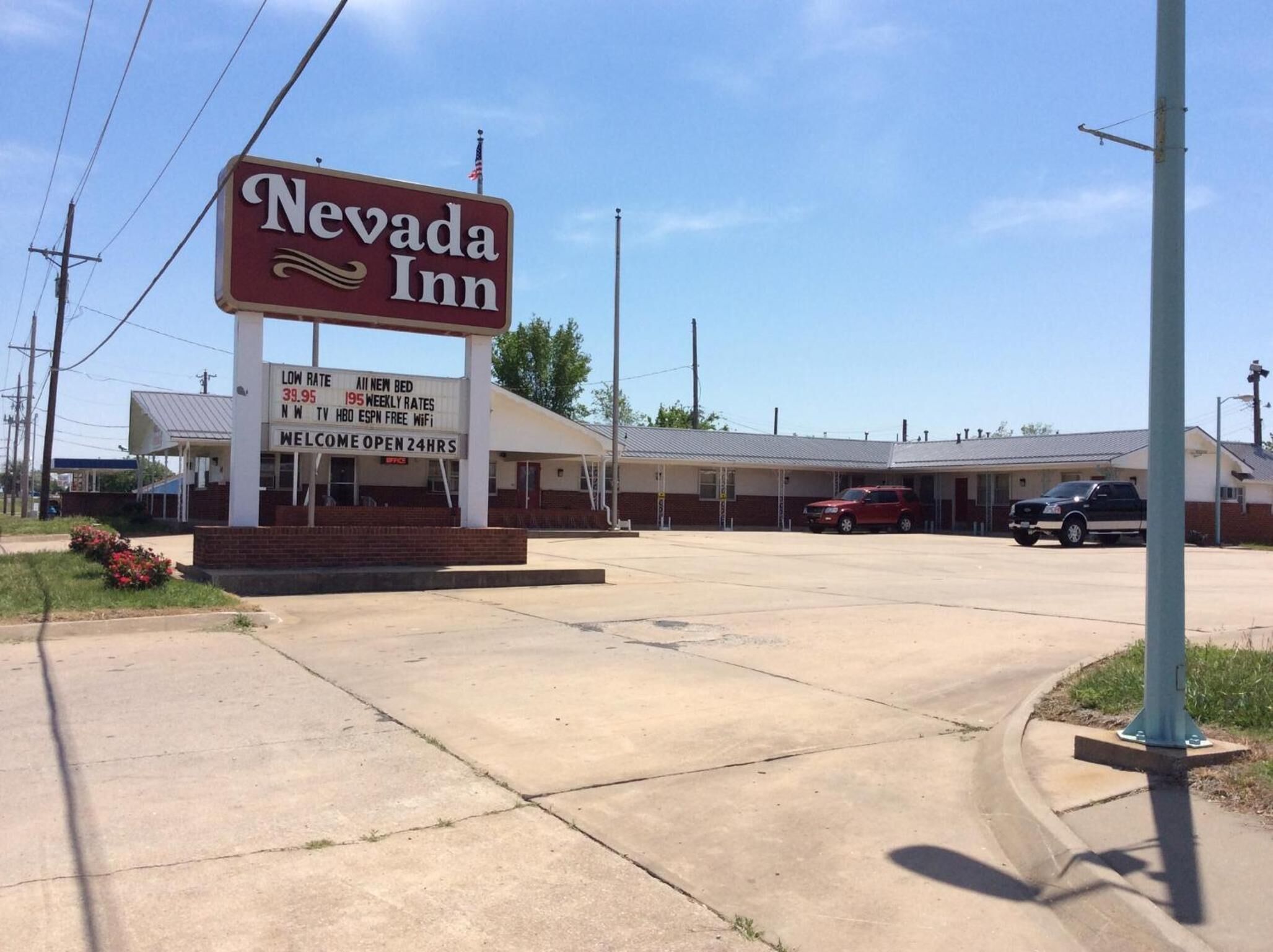 A Nevada Inn sign with a clear view of the building's entrance and parking area.