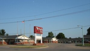 A Nevada Inn with a prominent red sign, a parking lot, and a few buildings in the background.