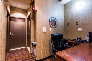 A hotel lobby with a reception desk, a black leather chair, a wall-mounted sign for Hotel Five44, and a door labeled '2'. - Hotel Five44 (New York)
