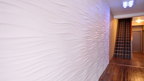 A modern interior with a textured wall and a wooden floor.