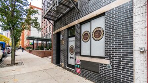 A hotel facade with a brick exterior, large windows, and a fire escape.