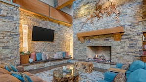 A stone-walled living room with a fireplace, sofas, and a coffee table.
