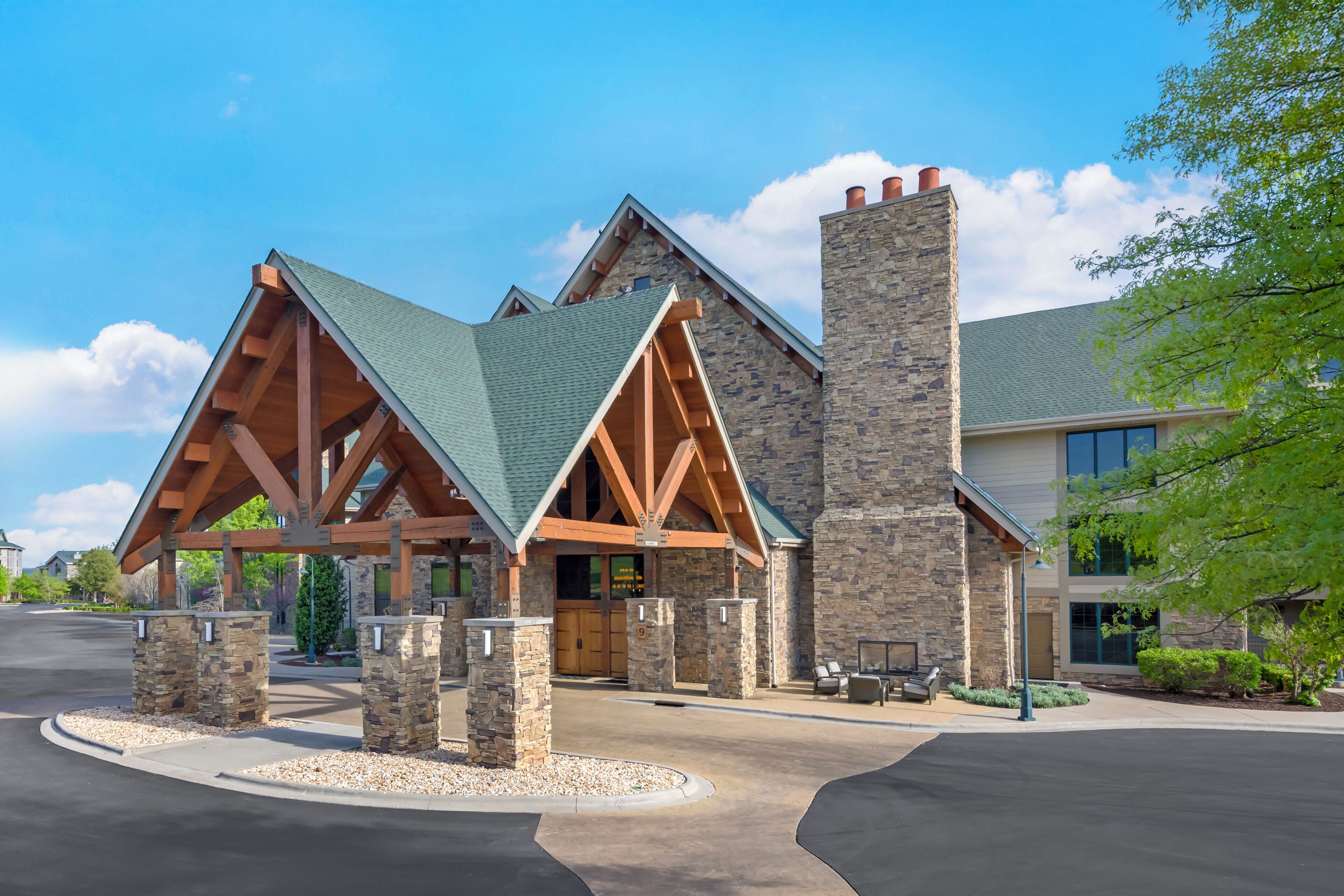 A building with a stone facade, wooden beams, and a green roof.