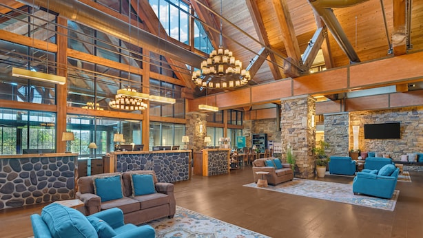 A spacious lobby with high ceilings, stone walls, and multiple seating areas.