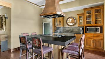 Una cocina moderna con una isla central, armarios de madera y un microondas integrado.