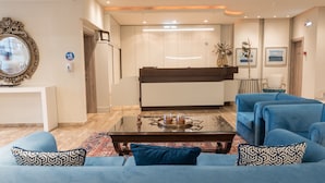 Una sala de estar moderna con un conjunto de sofás, una mesa de centro y una cocina al fondo.