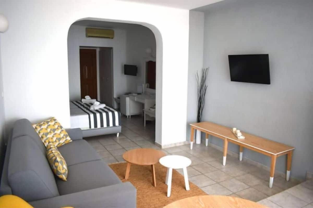 A modern living room with a grey sofa, a wooden bench, and a small round table.
