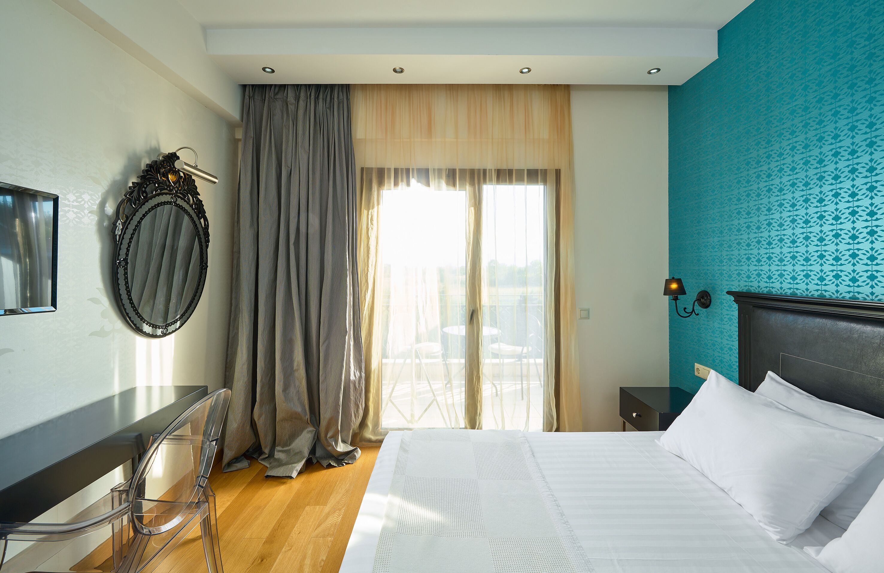 A hotel room with a bed, a desk, and a chair.
