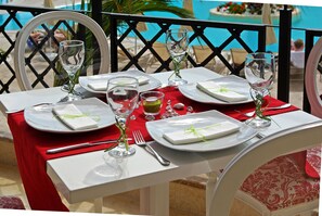 A table set for dining with white plates, clear glasses, and a red tablecloth. - Mediterranean Princess - Adults Only (Katerini)