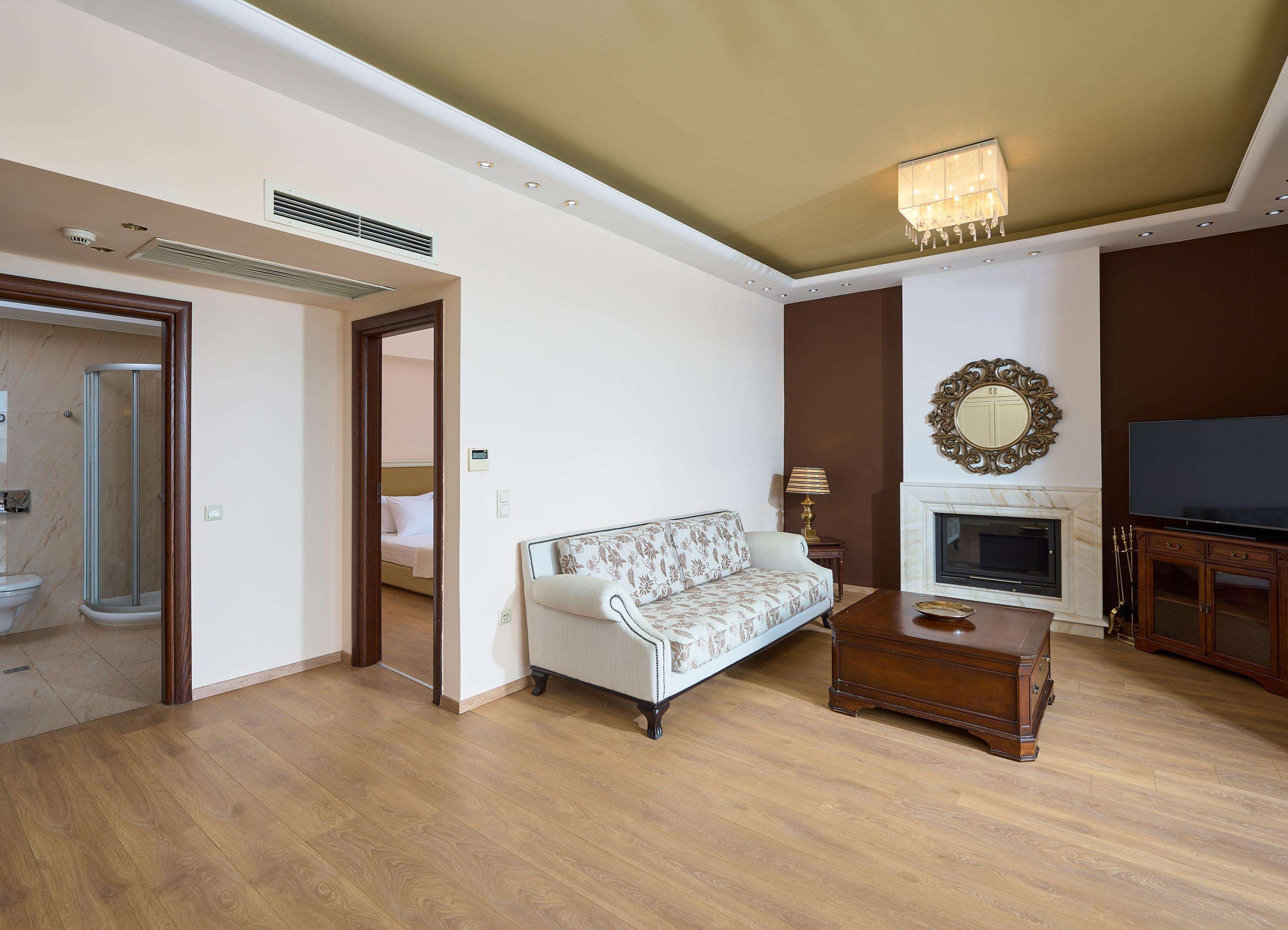 Una sala de estar con sofá, chimenea, televisor y una mesa de centro de madera.