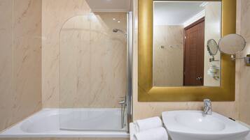 Un baño con bañera, lavabo y ducha.