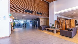 A spacious lobby with a wooden slatted ceiling, a reception desk, sofas, and a coffee table. - Wyndham Concepcion Pettra (Hualpén)