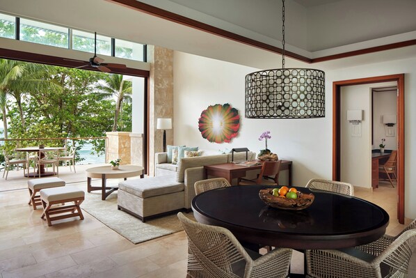 A spacious living area with a round dining table, wicker chairs, a sofa, and a view of the outdoors. - Dorado Beach, a Ritz-Carlton Reserve (Dorado)