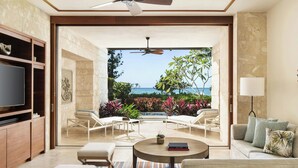 A spacious living area with a television, seating, and a view of the ocean.