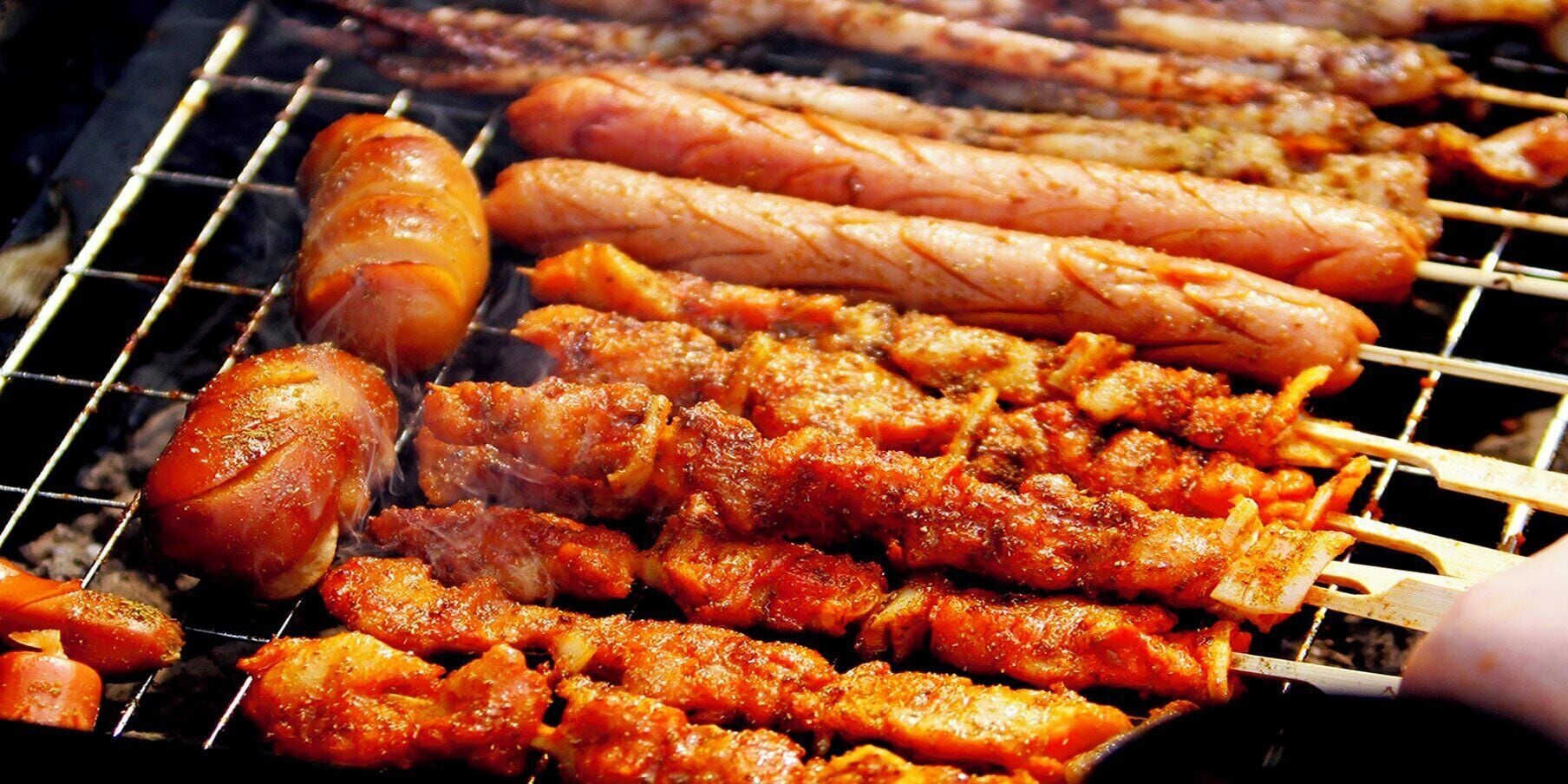 A grill with various meats being cooked.