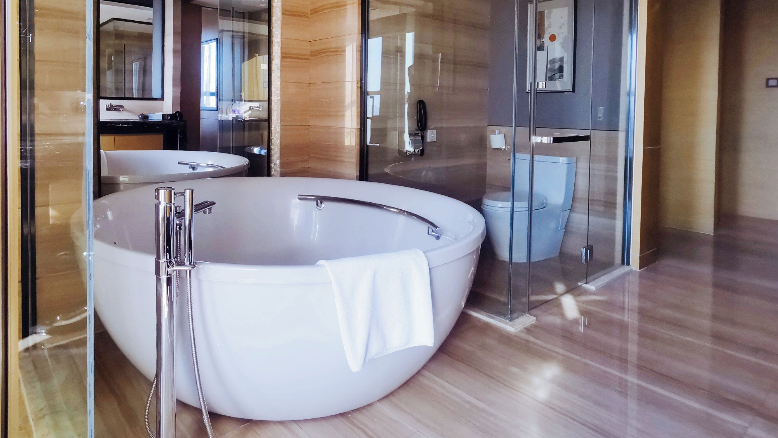 Un baño moderno con una bañera independiente grande, ducha con cerramiento de vidrio y un inodoro separado.