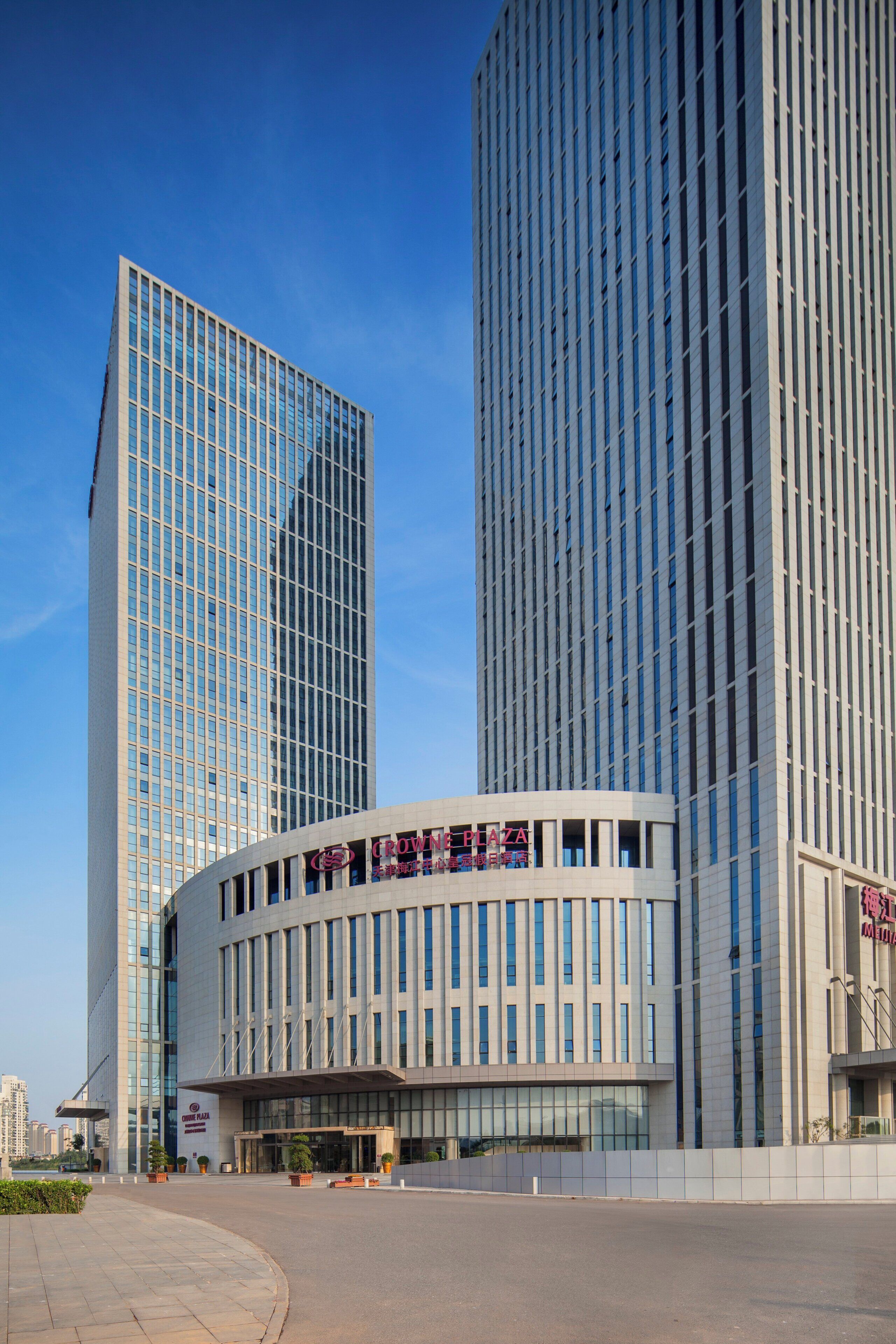 A modern building with a curved facade and a flat roof.