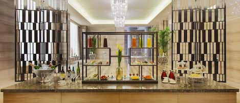 Una cocina moderna con encimera de mármol, una isla central con cristalería y un candelabro decorativo.