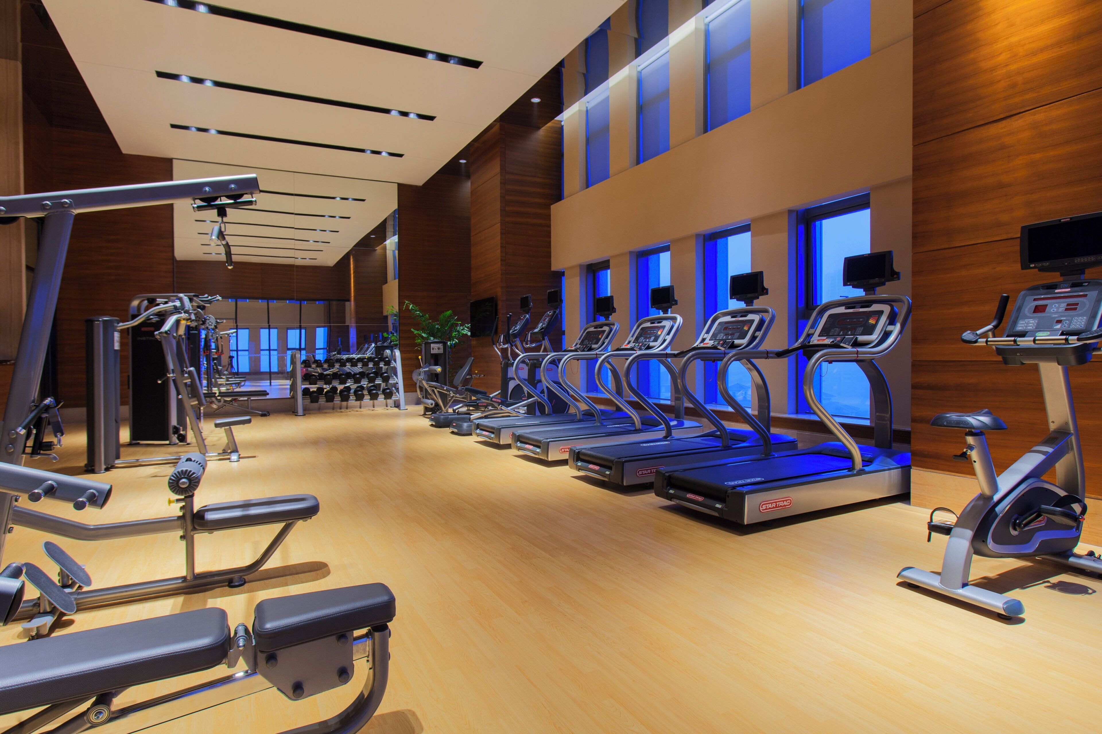 A gym with treadmills, exercise bikes, and weight machines.