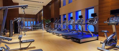A gym with treadmills, exercise bikes, and weight machines.