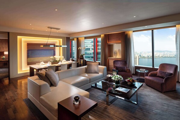 Un salon moderne comprenant un canapé, des fauteuils, une table basse et un coin repas avec une table et des chaises.
