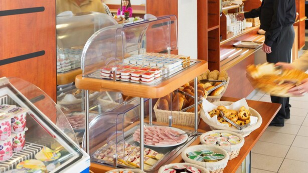 Ein Buffet mit verschiedenen Speisen, darunter Backwaren, Fleisch und Milchprodukte.