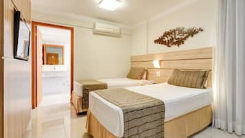 A hotel room with two beds, a bathroom, and a mirror.