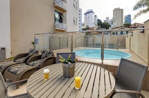 Piscina externa, guarda-sóis, espreguiçadeiras