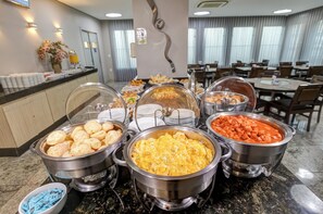 A buffet with various food items, including bread, eggs, and a red sauce dish. - BH Jaraguá Hotel (Belo Horizonte)