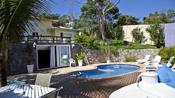 Una piscina al aire libre, sillones reclinables de piscina