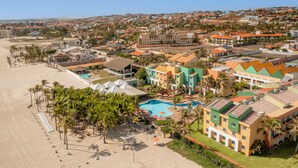 A coastal resort with multiple buildings, a swimming pool, and a beach area with palm trees. - Beach Park Oceani Resort (Aquiraz)