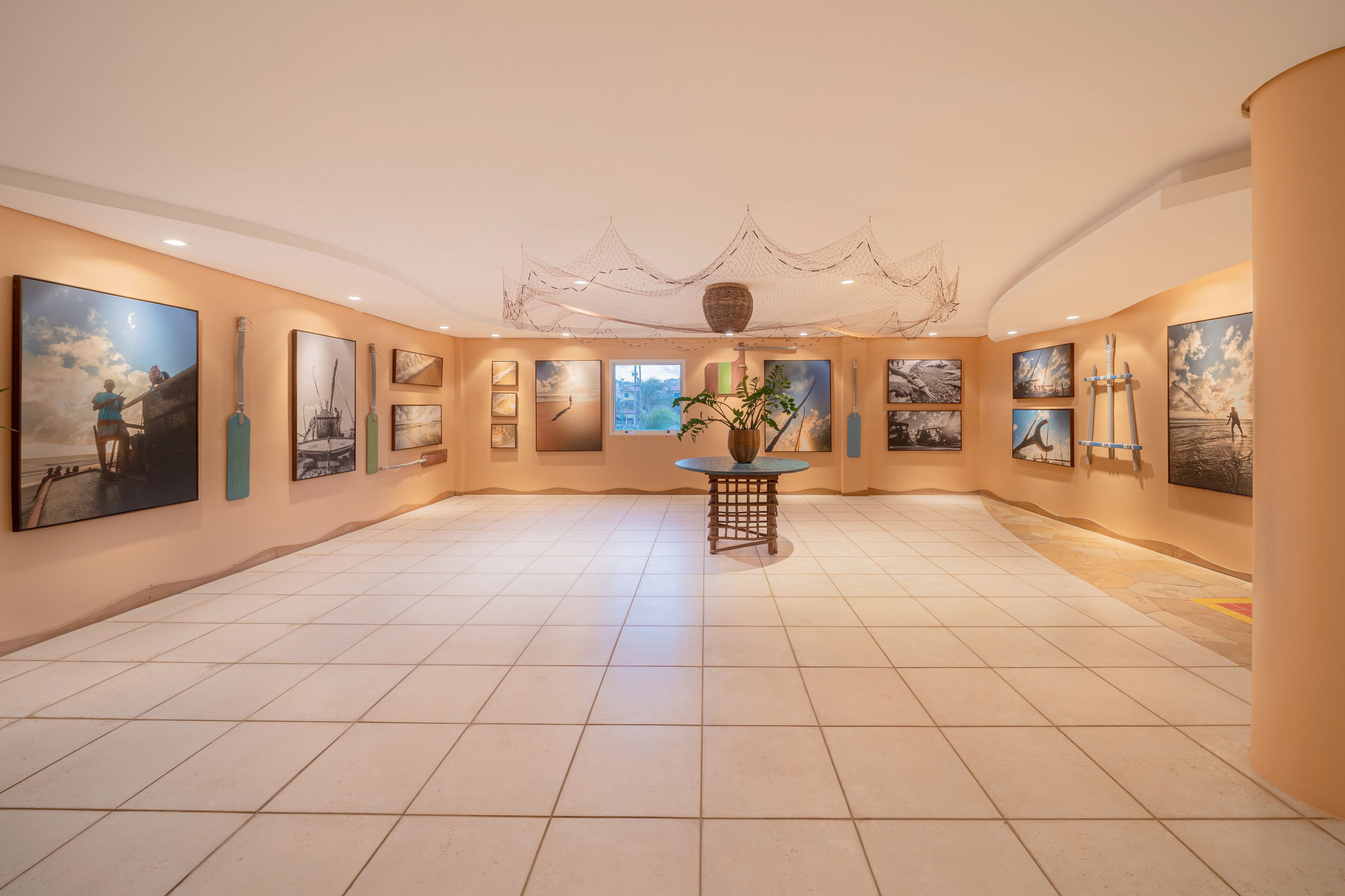 A spacious gallery with a tiled floor and walls adorned with various artworks.