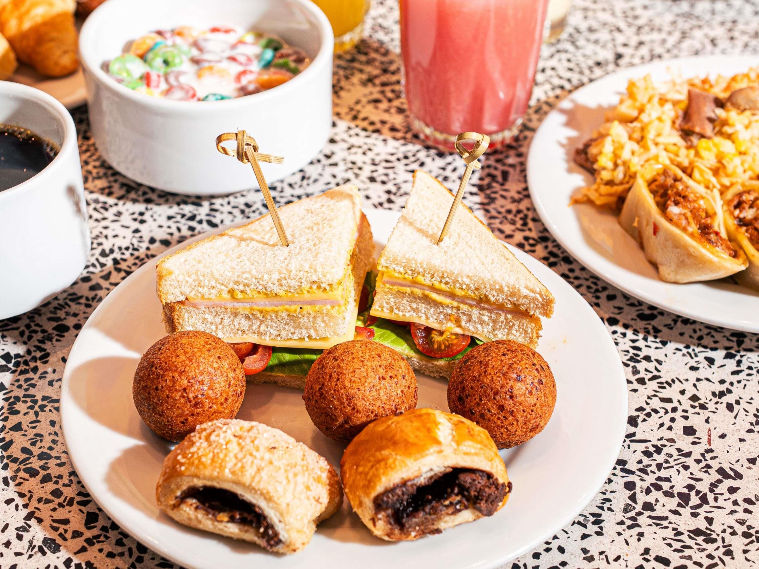 Un plat amb un entrepà, croquetes i un bol de sopa.