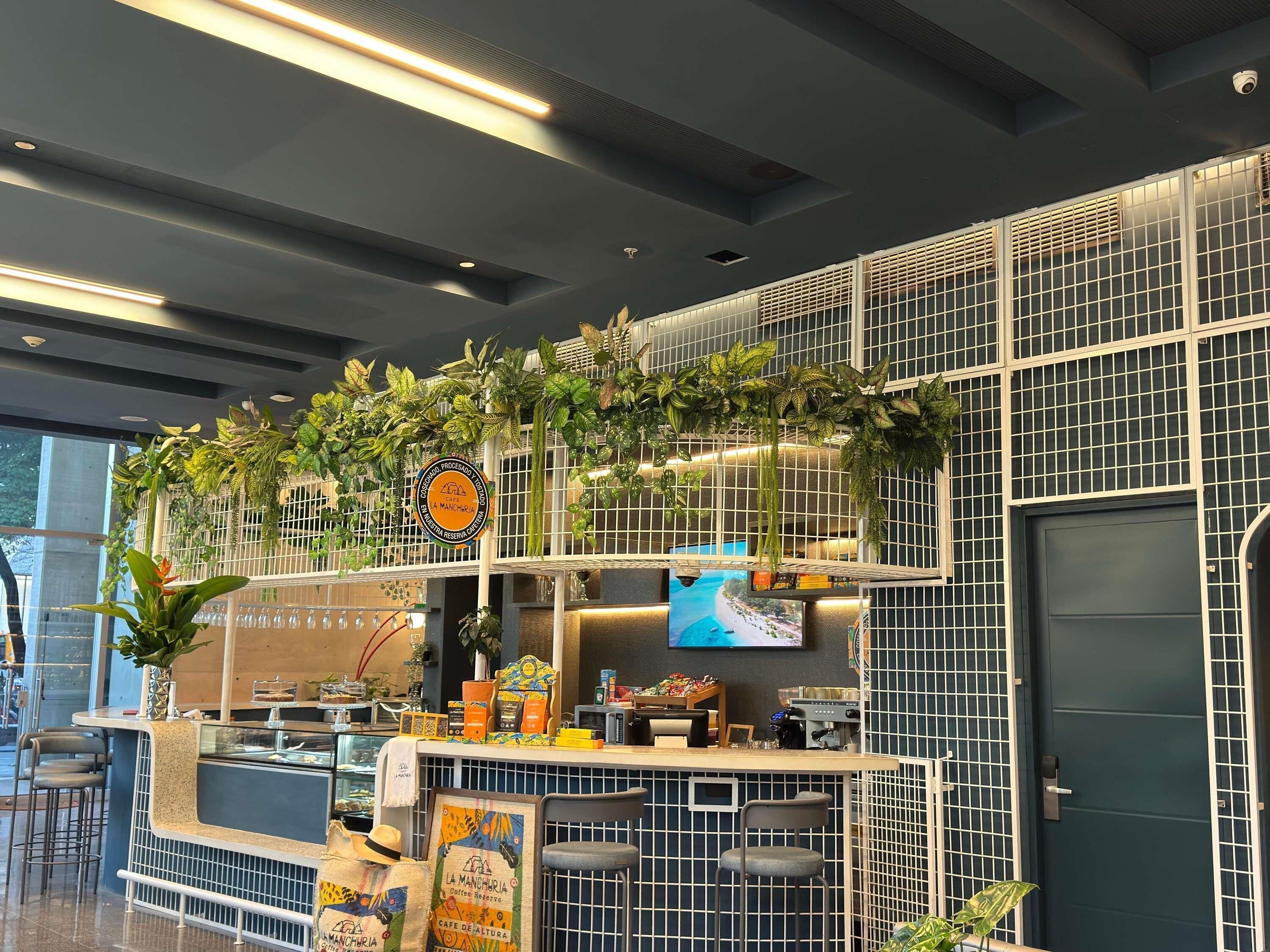 A cafe with a counter, seating, and a TV screen.