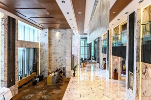 A spacious hotel lobby with marble flooring, a reception desk, and a seating area. - Renaissance Shanghai Caohejing Hotel (Shanghai)