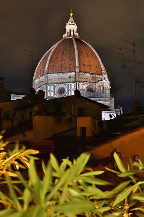 A large, historic building with a prominent dome and a clock tower, surrounded by urban structures. - Art and Luxury Apartments (Florence)