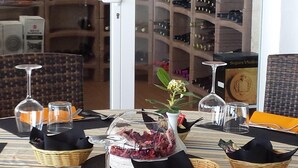 Une table à manger dressée avec des verres à vin, un centre de table orné de fleurs et des paniers.