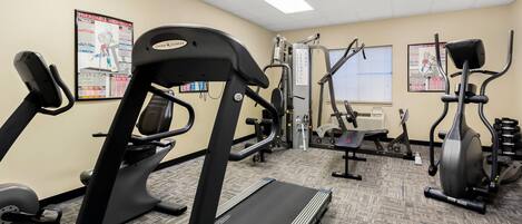 Una palestra con tapis roulant, ellittiche e attrezzature per l'allenamento con i pesi.