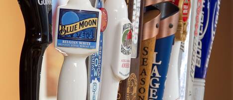 Una fila de grifos de cerveza con diferentes marcas y tipos.