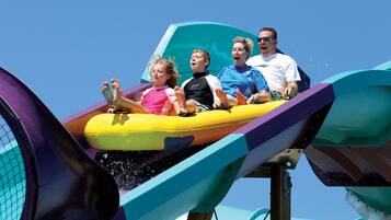 A water ride with a yellow raft and a clear blue sky in the background.
