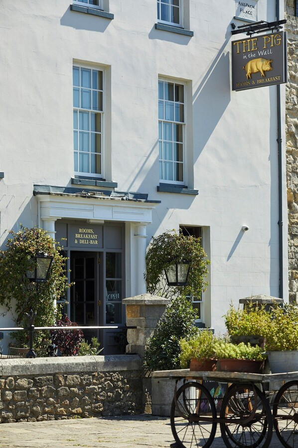 A building with a sign reading 'The Pig in the Wall' indicating rooms and breakfast.