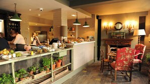 Un restaurante con barra, suelo de madera y chimenea.