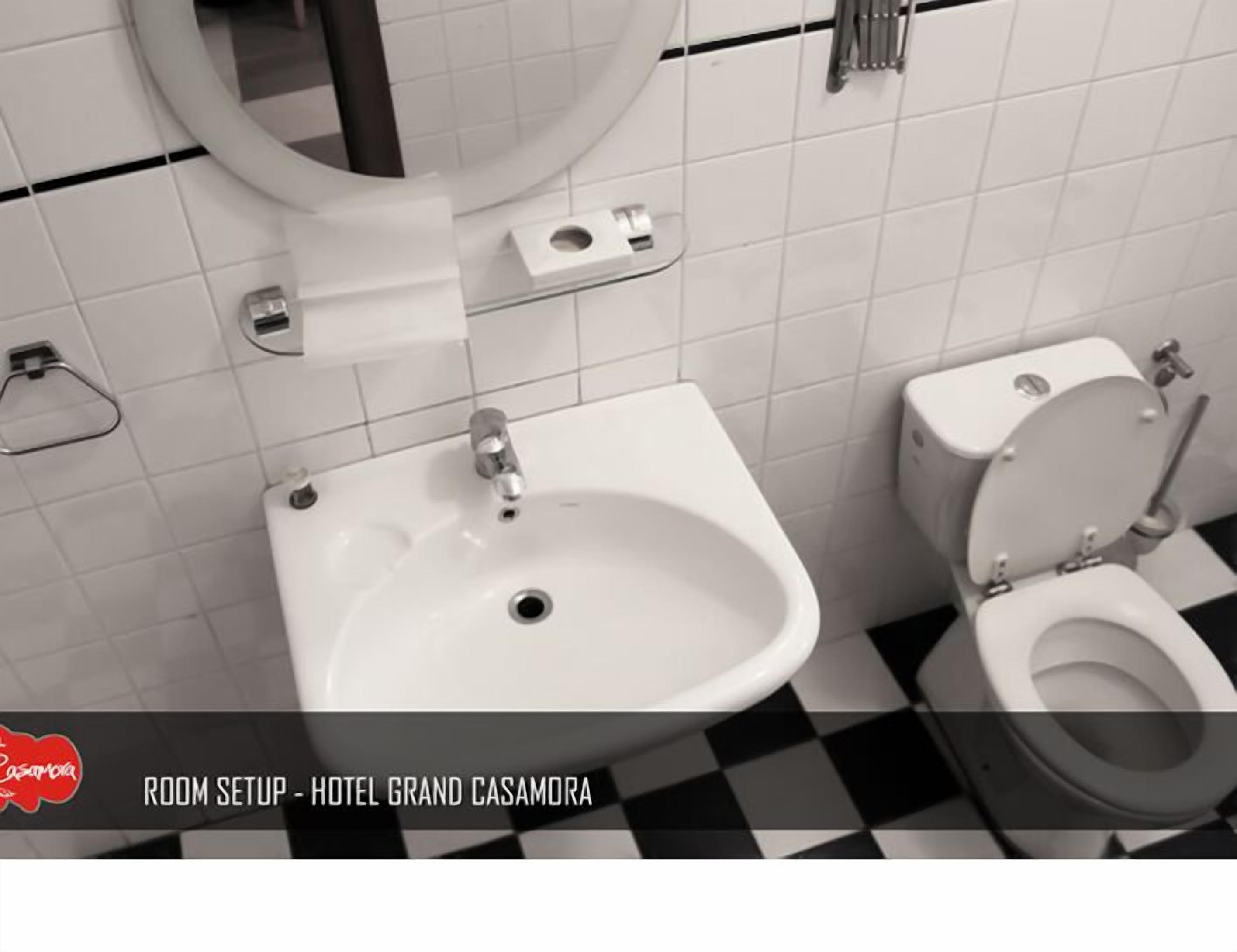 Un baño con lavamanos, inodoro y espejo.