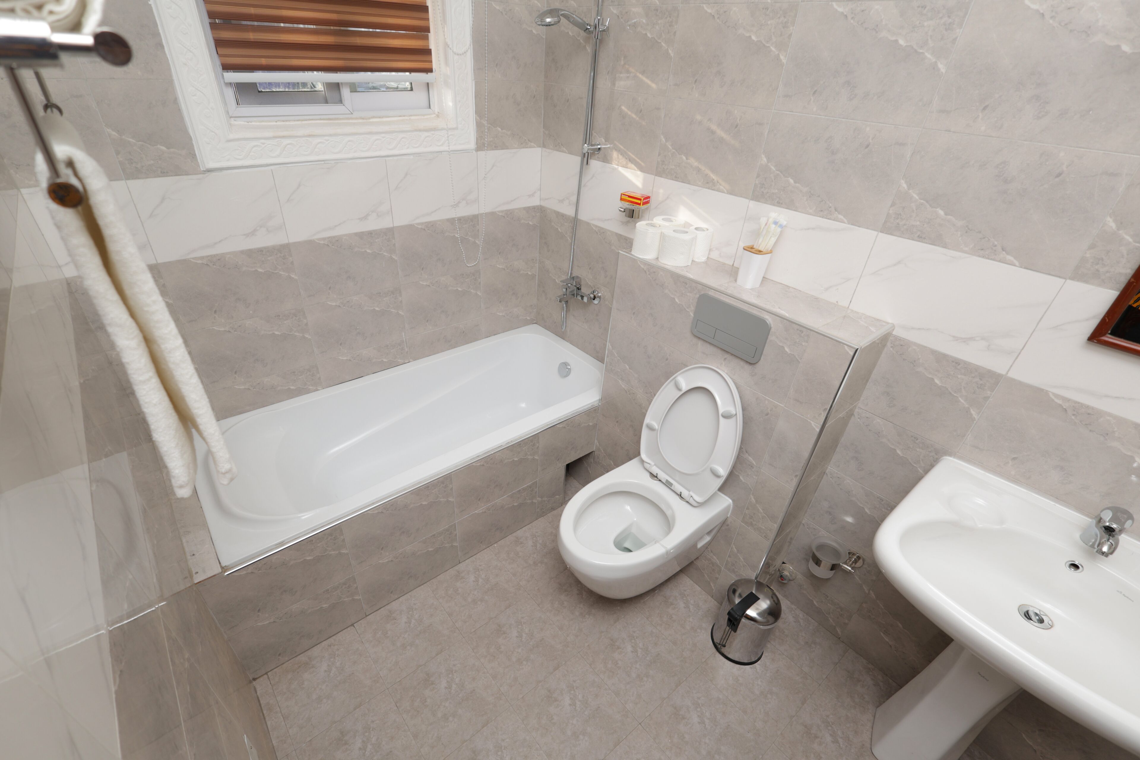 A modern bathroom with a bathtub, toilet, and sink.