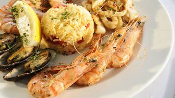 Una bandeja de mariscos con camarones, mejillones y calamares, decorada con hierbas y limón.